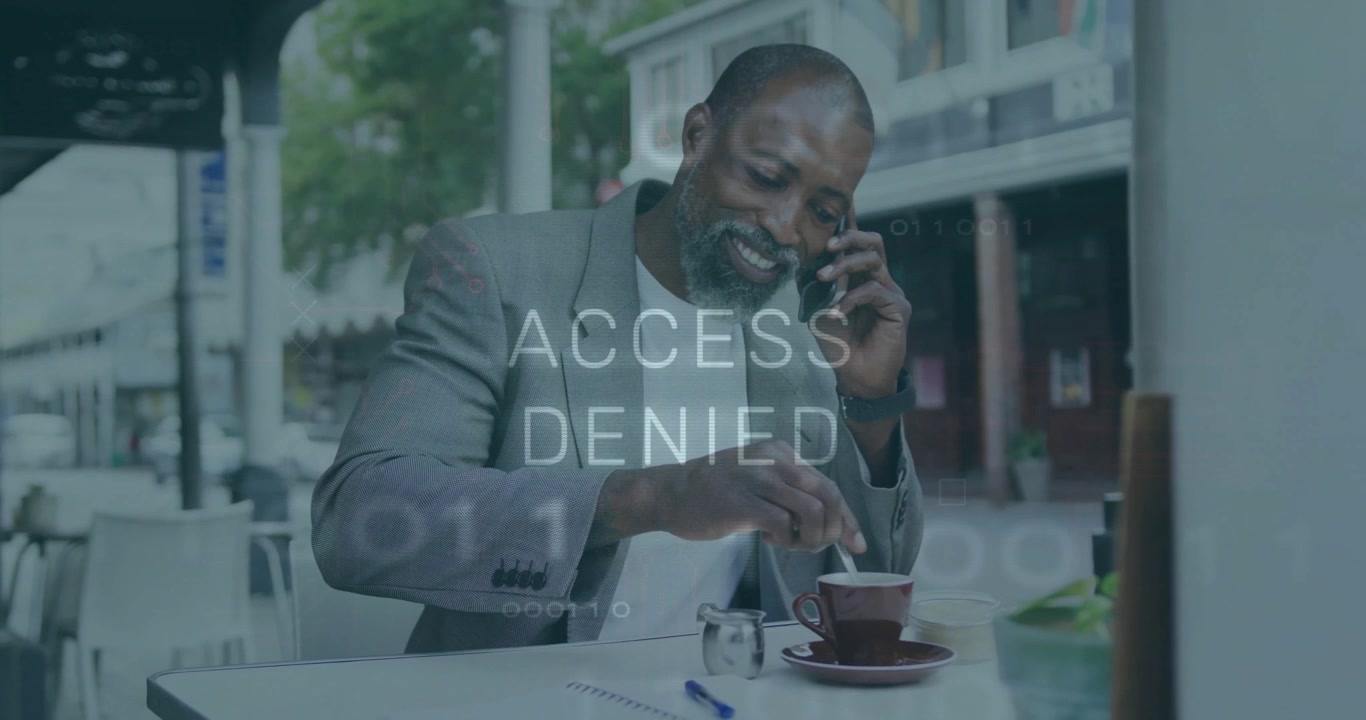 Businessman lifting smartphone stirring coffee on cafe table, causing ACCESS DENIED overlay fading