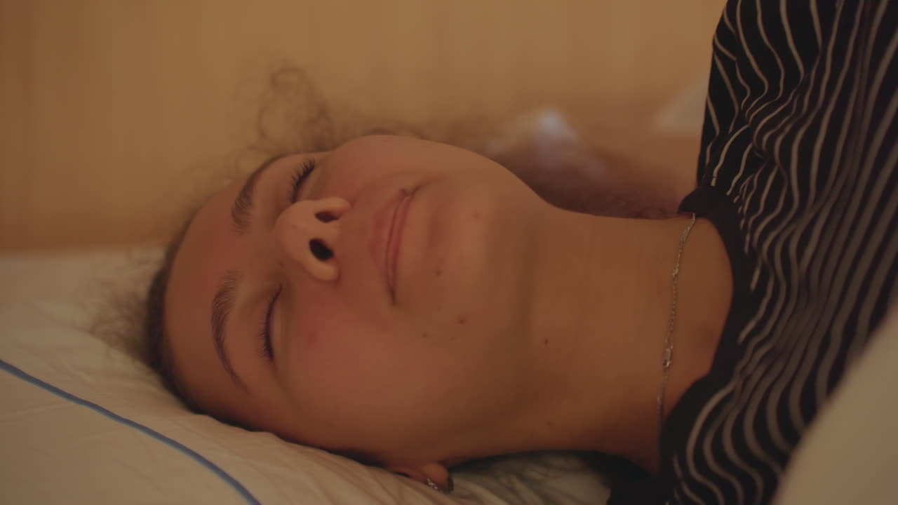 Sono tranquilo no hotel. Mulher serena deitada confortavelmente na cama do hotel. Senhora calma dormindo profundamente em um ambiente aconchegante de quarto de hotel. Mulher tranquila dormindo pacificamente em uma cama quente de hotel após uma sessão de estudos.