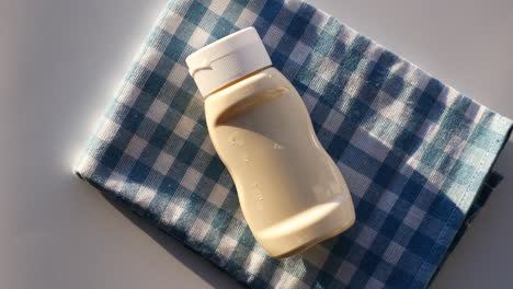 bottle of sauce on a checkered napkin