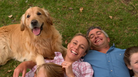 familia feliz sonriendo a la cámara con su perro