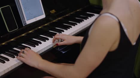 woman playing piano with digital sheet music