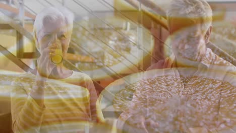 animation of cut oranges over happy caucasian senior couple drinking orange juice at home