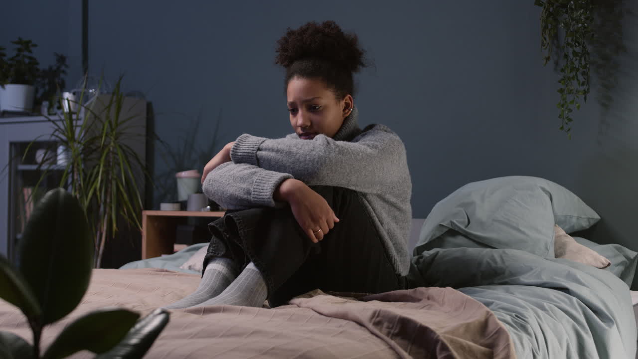 Sad teenager sitting on her bed