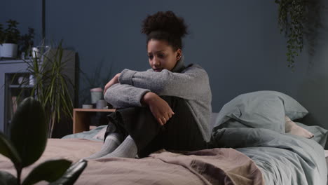 sad teenager sitting on her bed