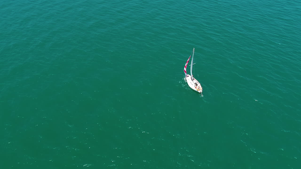Sailing boat. Yacht sailing on the sea. Boat swimming on beautiful water background. Sailboat cruising in the sea. Aerial view.