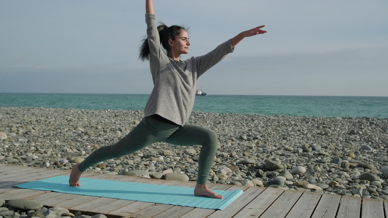 해변 에서 요가 를 연습 하는 여자