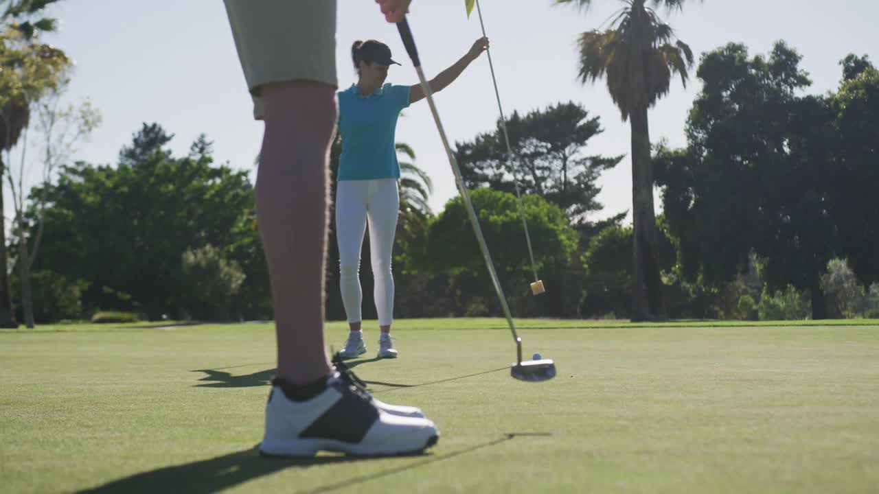 두 명의 백인 여성이 골프를 치고 얼굴 마스크를 쓰고  ⁇ 커에서 총을  ⁇ 고 있습니다.