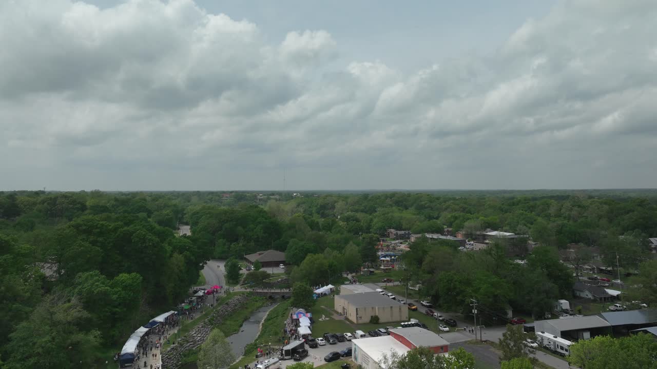 drone hiperlapso vista del 50 aniversario del festival de dogwood en siloam springs, arkansas con el video del dron moviéndose hacia adelante