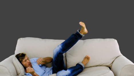 man jumping on the sofa on grey background