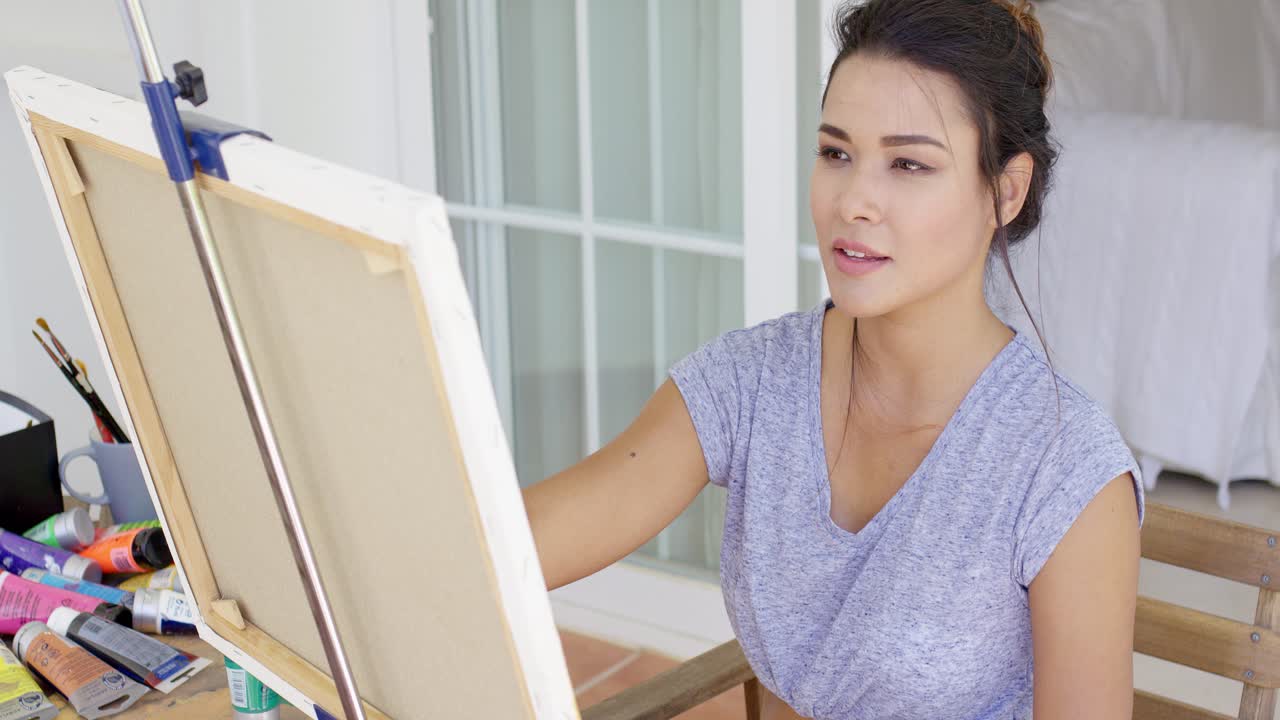캔버스를 그리는 매력적인 젊은 여성 예술가