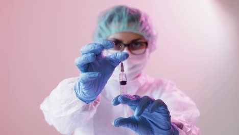 nurse wearing protective mask and gloves preparing an injection on hospital room with patients infected by coronavirus