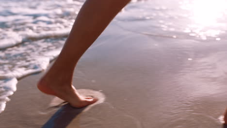 Woman,-beach-and-feet-walking-along-ocean