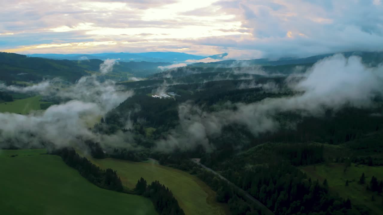 Aerial flying through mist revealing stunning rural landscape with green forest in mountains, tatra national park slovakia