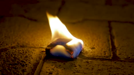 burning object on cobblestones at night