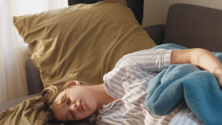 Woman Sitting In Bed Staring Out Window In Quiet Morning Light, Reflective Posture With Knees Drawn Up, Striped Pajamas And Soft Blanket, Pensive Atmosphere And Gentle Interior Tones