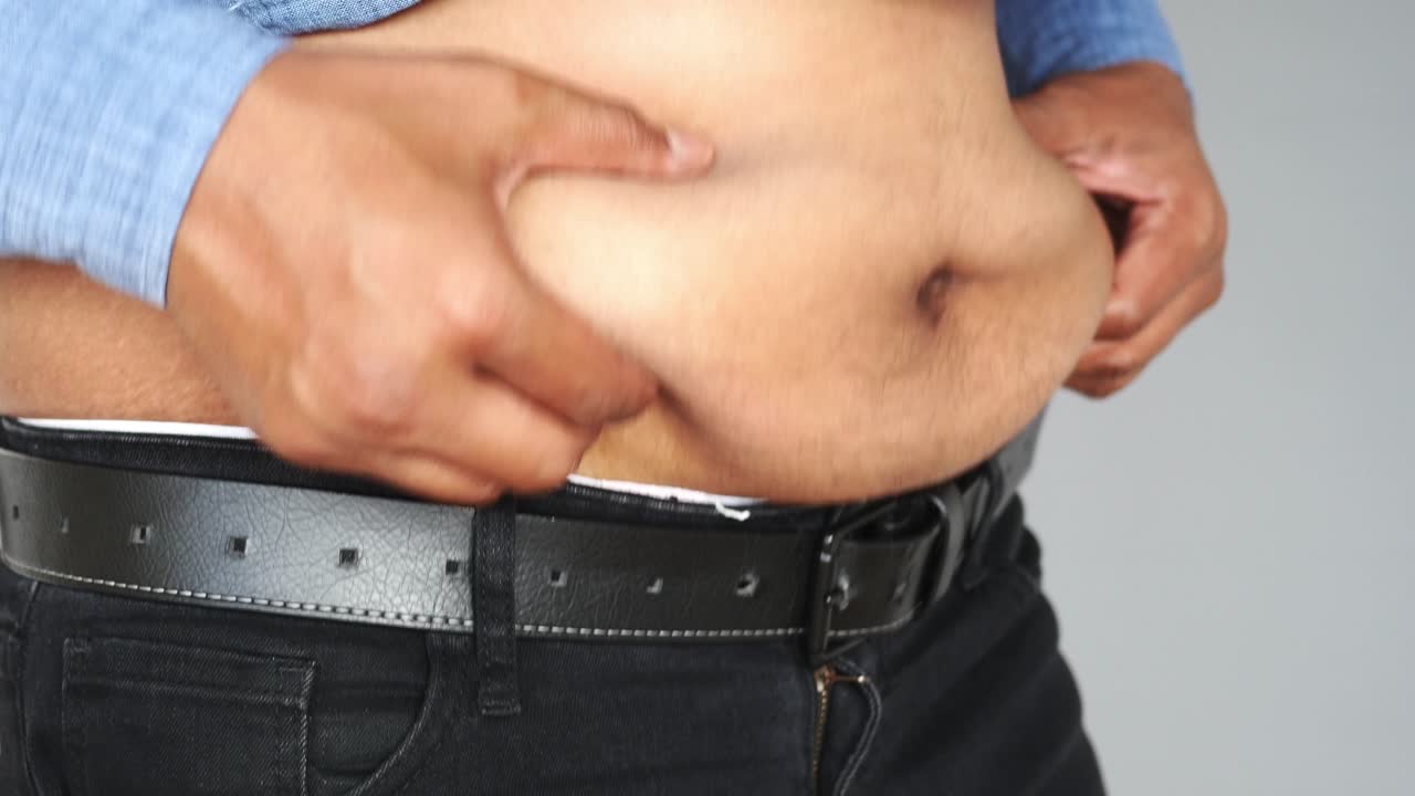 hombre comprobando su grasa abdominal