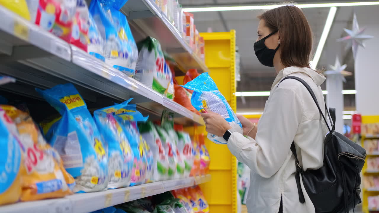 mujer comprando detergente para la ropa en una tienda de comestibles