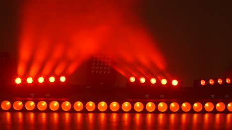 closeup of bright red and orange lights on stage beaming then turning off