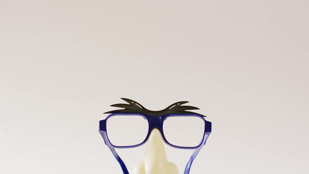 vídeo de cejas de plástico adjuntas, gafas, nariz y bigote sobre fondo blanco con espacio para copiar