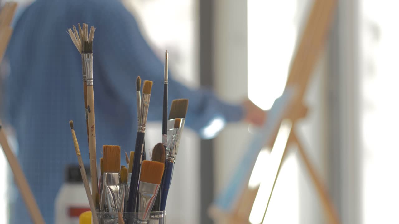 예술 스튜디오에서 그림을 그리는 예술가는 초점을 맞춥니다