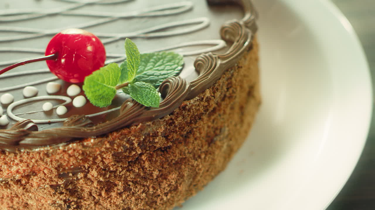 mujer de primer plano con la mano decorando el pastel con cereza en cámara lenta.