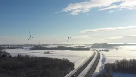 Aerial-view-of-windmills-and-highway-in-cold-winter-day