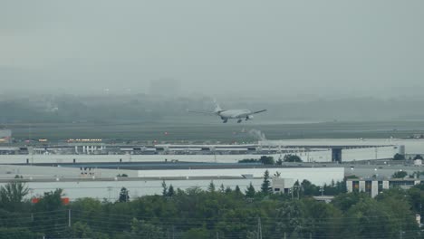 wide shot of airplane landing on runway of the airport during dark clouds and thunderstorm.toronto,canada.