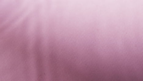 video of close up of waves of water with copy space on pink background