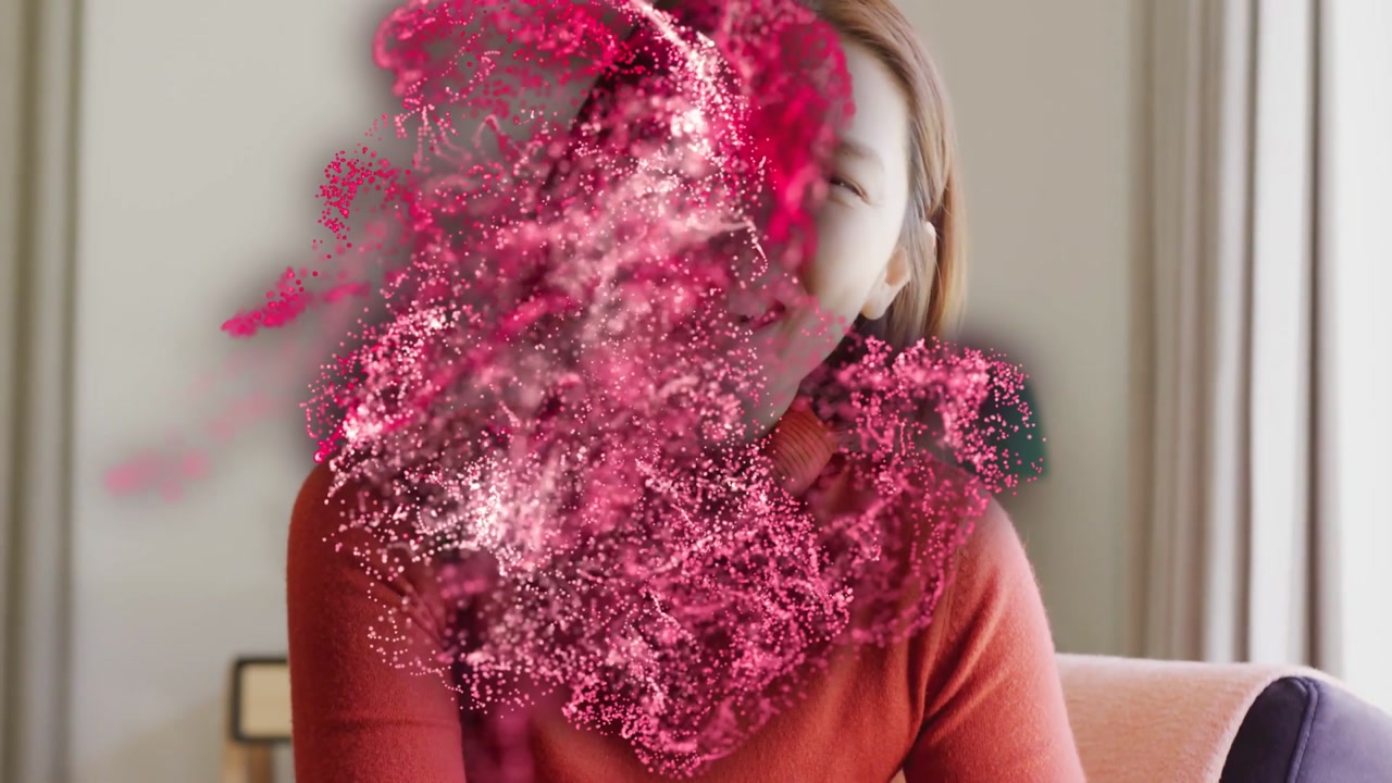 Vertical video: Touching hair, Asian woman in rust-red sweater at home pink cloud emerging laughing