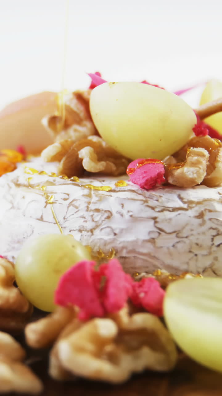 postre de queso adornado con nueces y uvas