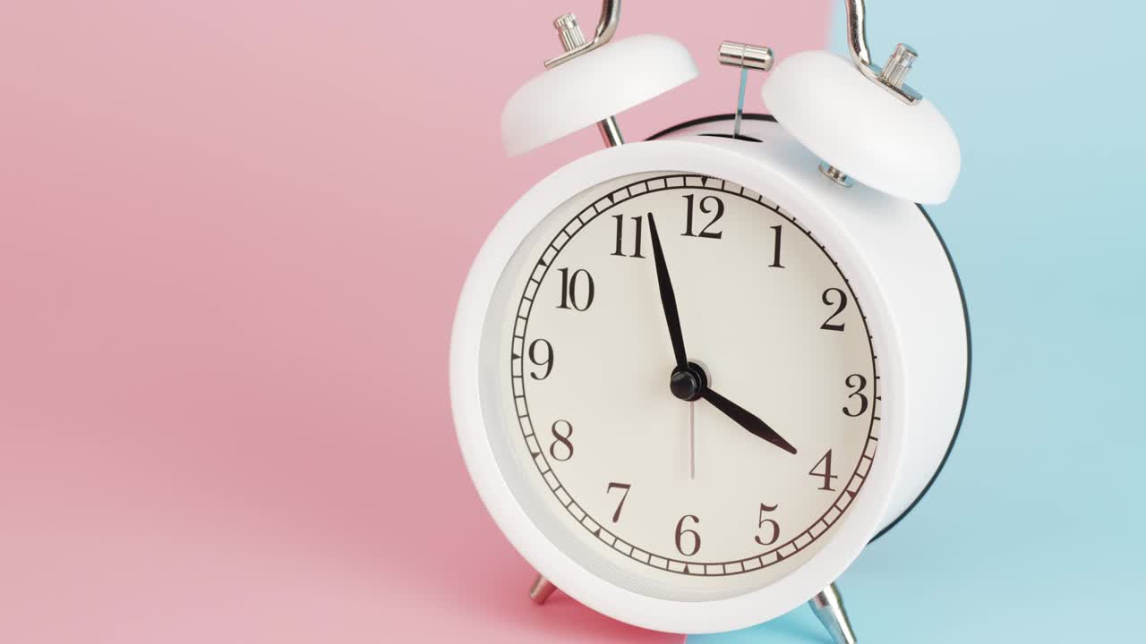 Zoom in White alarm clock telling time 8 o'clock.