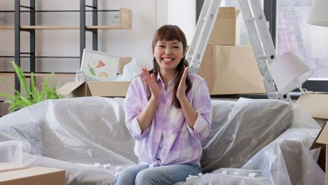 Women-with-Box-and-Foam-Peanut-Moving-to-New-Home.moving,-people-and-real-estate-concept--women-unpacking-boxes,-throwing-foam-peanuts-and-having-fun-at-new-home