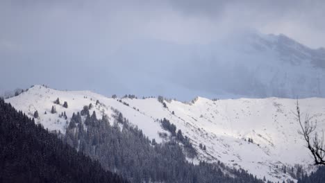 Timelapse-of-impressive-and-far-away-mountain-wall-emerging-and-disappearing-in-the-passing-low-clouds