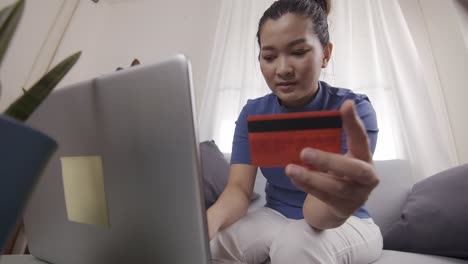 New-normal-Asian-women-are-using-cards-to-pay-for-online-shopping-on-a-laptop