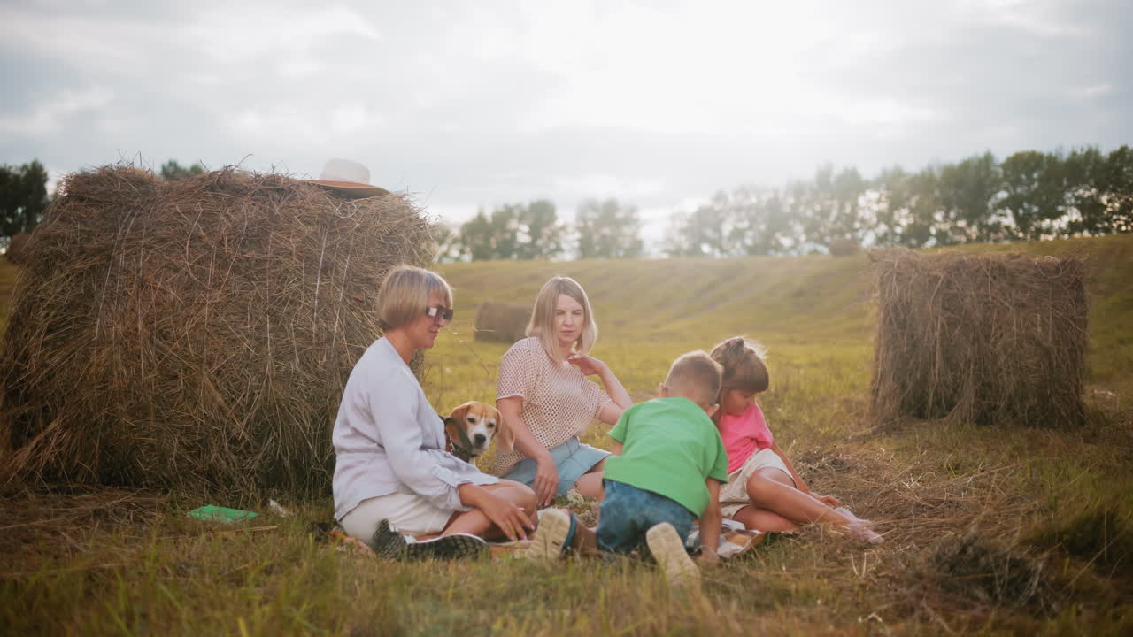 행복한 가족은 야외에서 간식과 함께 야외 피크닉을 즐기고, 빛은 따뜻한 빛을 고, 뒷면에는 풀과 나무가 있습니다.