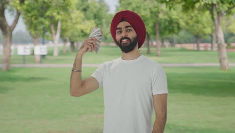 sikh indian man using money as fan in attitude in park