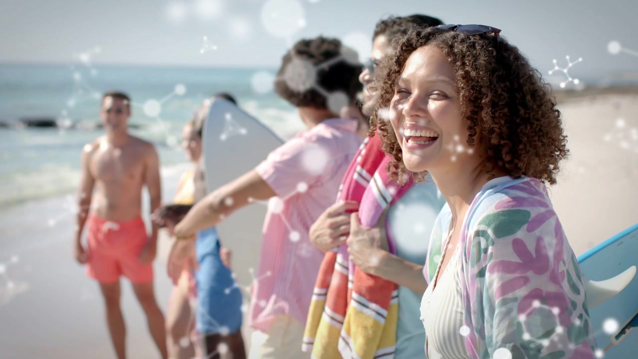 Donna che ride mentre la telecamera panoramica, gruppo che sistema le tavole, luce che luccica sui volti mentre si preparano a fare surf