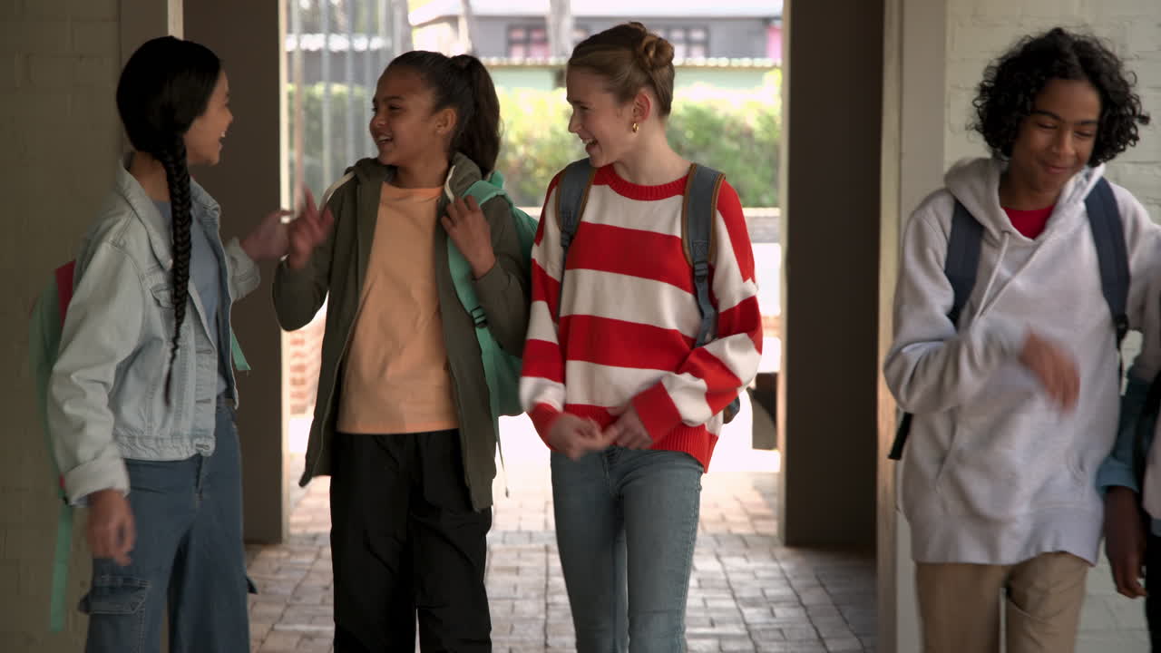 Diverse group of multiracial students walking together at school, laughing and chatting