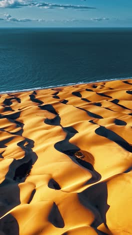 impresionante vista aérea de las dunas de arena dorada que se encuentran con el océano en gran canaria