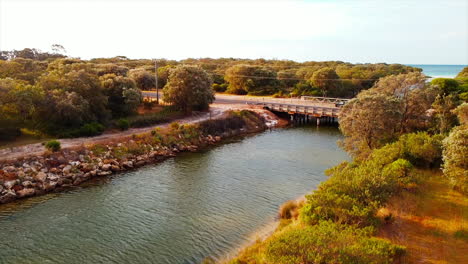 Drone-view-car-driving-on-multi-lane-bridge-road-over-Vasse-Wonnerup-river-in-western-Australia