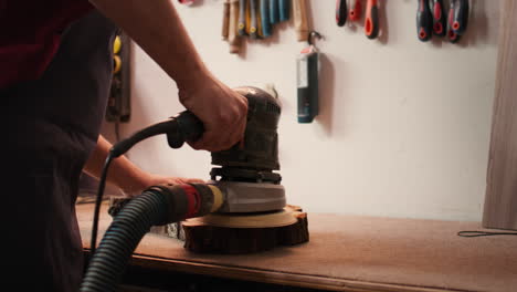 Carpenter-using-angle-grinder-on-timber-block-to-smooth-surfaces-with-sandpaper