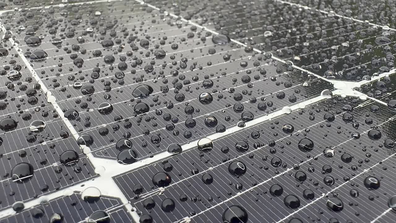 primer plano de un panel fotovoltaico con gotas de agua que caen