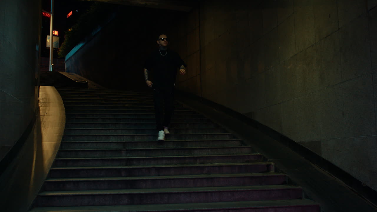 Man Walking Up Dark Urban Stairs at Night