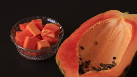 Rebanada-De-Papaya-Y-Jugo-De-Papaya-Sobre-Hojas-Verdes-Y-Fondo-Negro,-Fruta-Sana-Y-Dietética