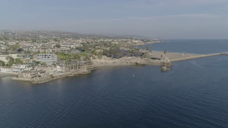 Aerial-shot-flying-towards-Pirates-Cove-and-Corona-Del-Mar-beach-over-Newport-Bay-in-summer-in-Newport-Beach,-California