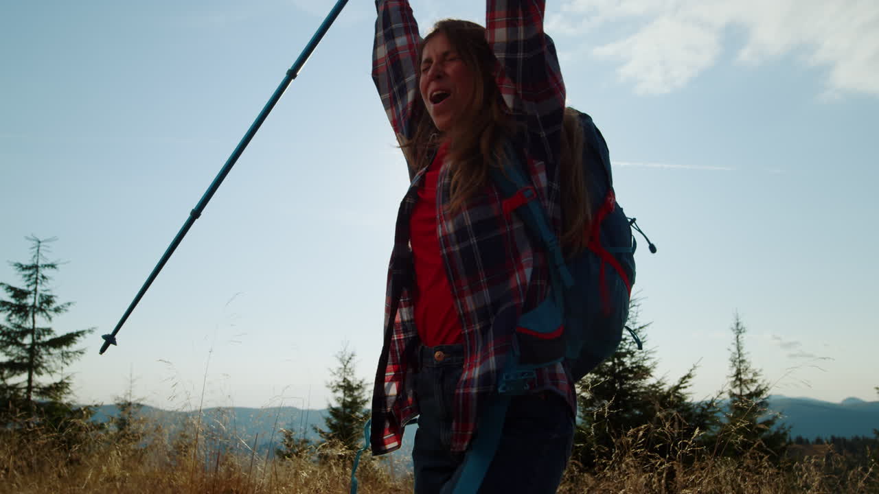 excursionista femenina celebrando en la cima de la montaña