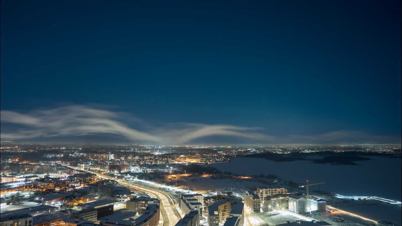 Timelapse del cielo notturno con l'aurora boreale sopra Helsinki innevata dalla torre di Kalasatama.