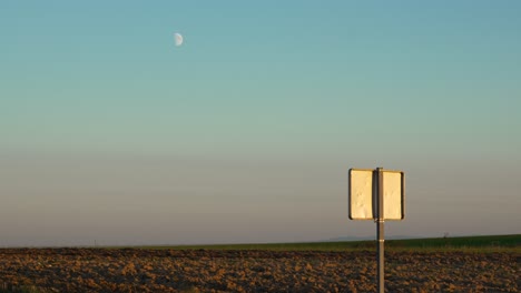 agriculture field, half quarter moon on the clear blue sky after sunset