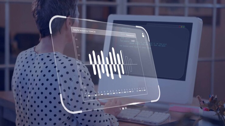 Woman typing on keyboard at desk activating hologram waveform panel over screen for audio review