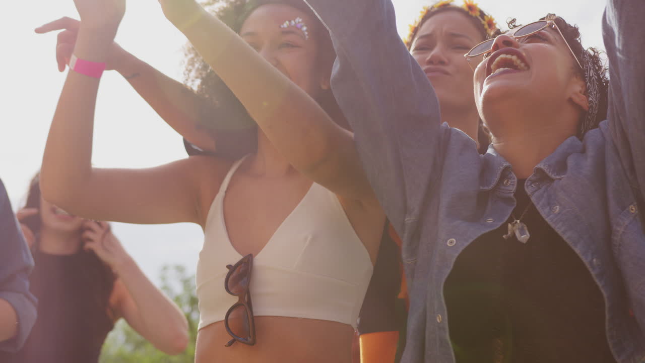 야외 음악 축제 에서 장벽 뒤 에 춤추는 젊은 친구 들 의 그룹